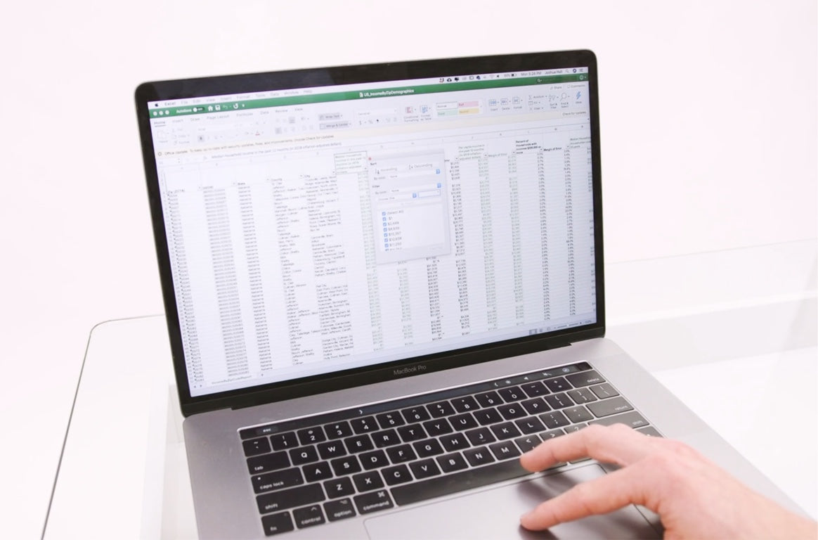 Photo of person using an Income By Zip Code list on a laptop
